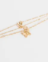Pulsera dorada de eslabones con tres cadenas y dije de mariposa con strass.