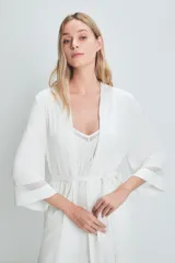Bata blanca de viscosa y elastano con mangas 3/4 y detalle de puntilla en los puños y el ruedo. Incluye cinturón para ajustar en la cintura.