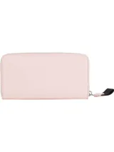 Billetera Tommy Jeans color rosa con cierre de cremallera, logo metálico plateado en el frente y correa de muñeca negra.