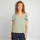 Blusa color verde claro con escote en V y mangas cortas con volantes.