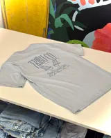 Remera celeste de corte oversize, confeccionada en jersey de algodón. Estampado en el centro de la espalda con el texto "Tribu Co. Est. 2023 Beach Social Club Girls Just Wanna Have Fun" y dos reposeras de playa.