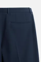 Pantalón de vestir negro slim fit, confeccionado en tejido con viscosa. Cuenta con bolsillos frontales y traseros de vivo. El cierre es frontal con cremallera y botón.