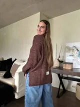 Sweater negro con hilo de lúrex plateado, de silueta holgada y cuello redondo a la base.