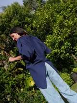 Camisa verde agua de lino, con botones de guampa, más larga atrás que adelante y espalda con tajo en el medio.