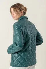 Campera de cuero negra con diseño matelassé de rombos, cuello camisero, cierre frontal con botones a presión, dos bolsillos delanteros y puños con botón.