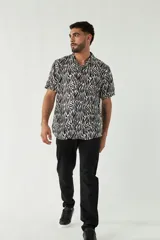 Camisa de hombre con estampado animal print blanco y negro, de corte slim, manga corta y cierre abotonado.