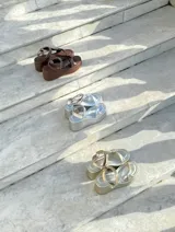 Sandalias doradas con plataforma, tiras cruzadas y hebilla al tobillo.