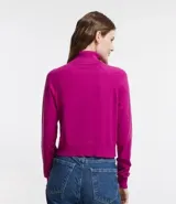 Blusa de punto color blanco, con cuello alto, manga larga y diseño liso.