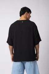 Remera negra de tejido tipo lino, corte holgado y cuello redondo. Sin estampas ni bordados.