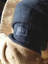 Buzo de punto grueso con bloques de color camel, azul marino y beige.