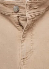 Pantalón de jean color beige, de corte culotte, tiro alto y bajo deshilachado.