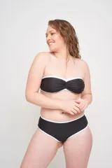 Conjunto de bikini azul con estampado de flores blancas. El corpiño es strapless con copa fija y bretel desmontable. La bombacha es tipo short con cintura alta.