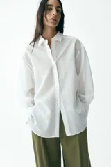 Camisa blanca con rayas verticales, cuello solapa, manga larga y cierre frontal con botones.