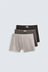 Pack de tres calzoncillos tipo bóxer confeccionados en tejido elástico con acabado aterciopelado y cintura elástica. Incluye un bóxer color gris claro, uno gris oscuro y uno marrón oscuro.