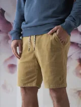 Bermuda beige de corte recto con cintura ajustable con cordón.