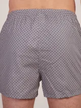 Bóxer de algodón con estampado floral en tonos azul y blanco, con cintura elástica y logo de la marca en el centro.