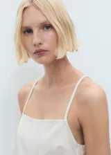 Minivestido blanco de algodón con breteles finos, escote cuadrado y cierre lateral con cremallera.