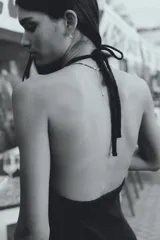 Vestido largo marrón de punto pointelle con estilo crochet, corte entallado, escote halter en V, adorno de metal en forma de sol en el centro del busto y falda sirena con bajo recto.