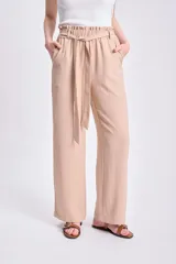 Pantalón color beige de corte ancho, con lazo ajustable en la cintura.