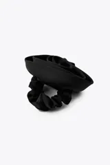Coletero elástico negro con aplique de flor y hoja en relieve.