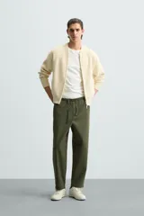 Pantalón verde militar de corte carrot fit, confeccionado en tejido de algodón. Cuenta con cintura elástica ajustable con cordón, bolsillos frontales y un bolsillo trasero de plastrón.