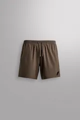 Pantalón corto deportivo color marrón oliva, con cintura elástica ajustable con cordón, bolsillos frontales y bolsillo trasero con cierre. Presenta forro interior y detalle de logo estampado en la pernera.