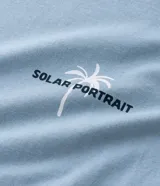 Musculosa masculina color celeste, de corte comfort, cuello redondo y sin mangas. Presenta un estampado localizado de palmera en el pecho.