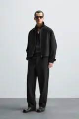 Pantalón negro de corte recto, con cintura elástica, bolsillos laterales y trasero.