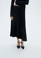 Falda midi plisada color negro, de tiro alto y corte evasé.