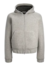 Campera gris melange con capucha, cierre frontal con cremallera, bolsillos laterales y puños elásticos.
