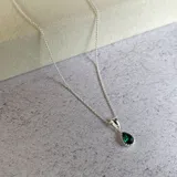 Collar de plata 925 con dije en forma de gota que contiene cristal verde oscuro.