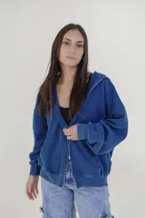 Campera azul con cierre frontal, capucha y bolsillos laterales.