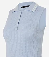 Top de punto sin mangas color negro, ajustado al cuerpo, con cuello polo que presenta ribetes blancos contrastantes. Tiene un cierre frontal de tres botones y un ribete blanco en el ruedo inferior.