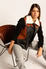 Campera negra con paneles de cuero color marrón, mangas largas de tejido de punto y cuello de piel sintética color crema.