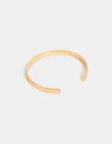 Pulsera rígida dorada tipo brazalete con dije de corazón.
