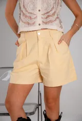 Short amarillo de gabardina con tiro alto y pinzas delanteras.