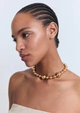 Top strapless color crudo, con frunces laterales y diseño asimétrico.