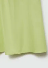 Falda larga color verde lima, de tiro medio y diseño evasé. Confeccionada en mezcla de algodón y lyocell, con cierre de cremallera invisible en la parte posterior.