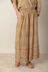 Pantalón palazzo de lino color crudo con estampado floral al tono, tiro alto y cintura elastizada.