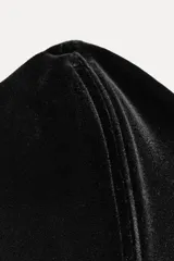 Vestido midi negro de terciopelo, palabra de honor con escote corazón y hombros descubiertos. Tiene detalle de elástico tipo nido de abeja en la espalda y abertura en el bajo.