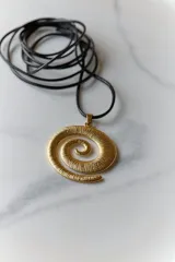 Collar con dije plateado en forma de espiral y cordón negro encerado.