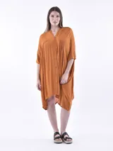 Vestido color naranja, corte irregular, con cuello en V y botones frontales.