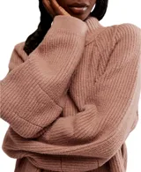 Sweater de tejido grueso color marrón, con cuello alto y mangas anchas.