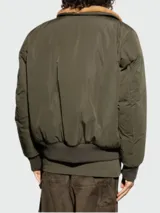 Chaqueta bomber verde militar con cuello de piel sintética color marrón, cierre frontal con cremallera, bolsillos laterales con solapa y bolsillo con cremallera en la manga izquierda.