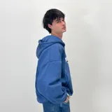 Campera con capucha azul con cierre frontal y bolsillos tipo canguro. Estampado frontal con el logo de la marca en color blanco.