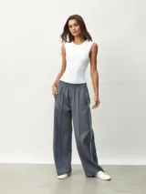 Pantalón deportivo color borgoña, de corte ancho y cintura elástica. Presenta una franja blanca vertical a lo largo de la pierna.
