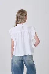 Blusa de viscosa color celeste, con cuello a la base, frunces y punto smock en el pecho y los hombros, y mangas cortas con volados.