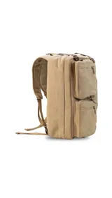Mochila de tela canvas color beige con detalles en cuero marrón. Cuenta con múltiples bolsillos con cierre, compartimento acolchado para notebook y correas ajustables.