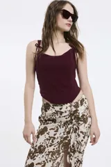 Top burdeos con breteles finos con lazos y escote con puntilla.