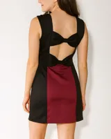 Vestido corto color bordó con paneles laterales negros, escote cuadrado y sin mangas.